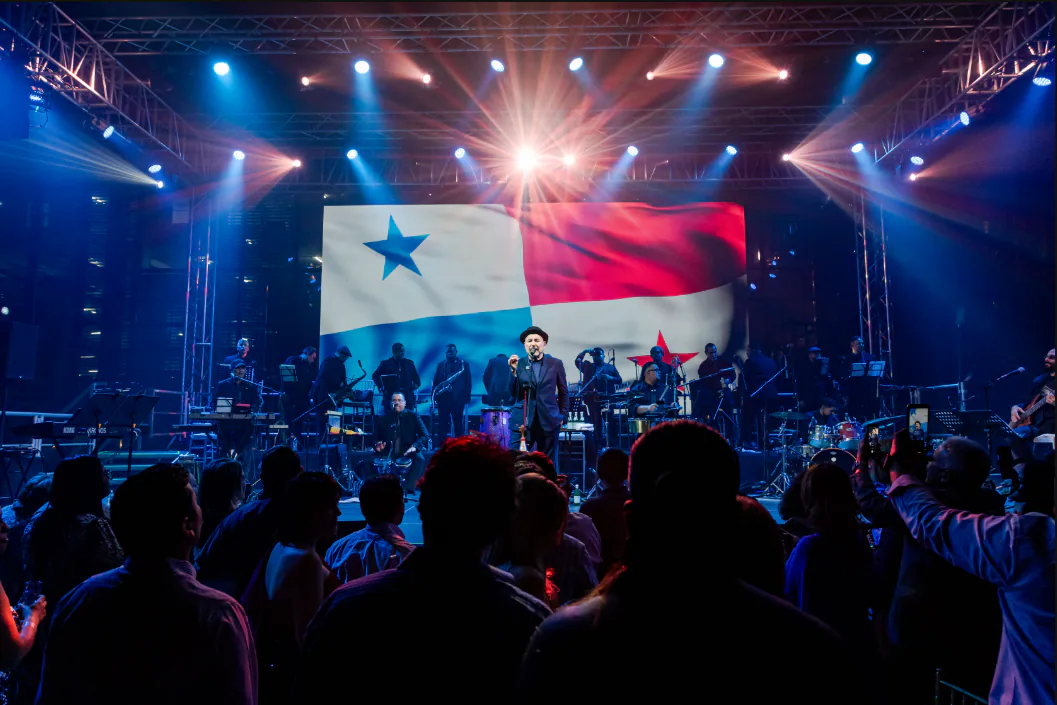 Rubén Blades durante su concierto Íntimo en Casa Veranda, acompañado por su banda y una producción de iluminación azul y roja
